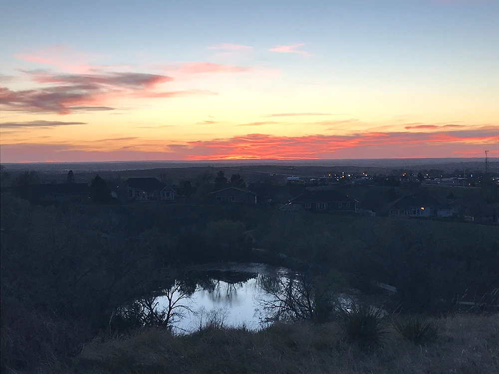 Landscape showing a sunset and a small pond