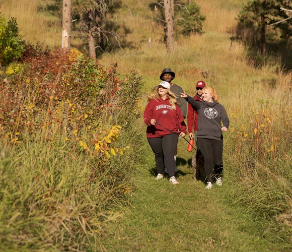 Group of people walking on a trail in the woods