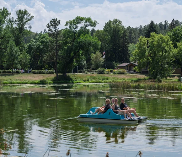 People in a paddleboat at a small pond