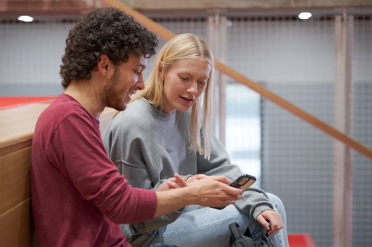 Two students look at a smartphone