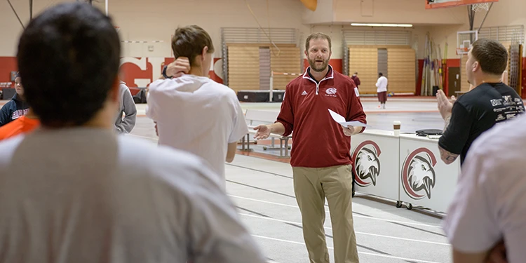 Coach talking to students at NPAC center on CSC campus, they are standing by the track