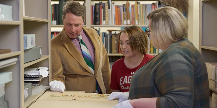 A history professor showing students items in an archive