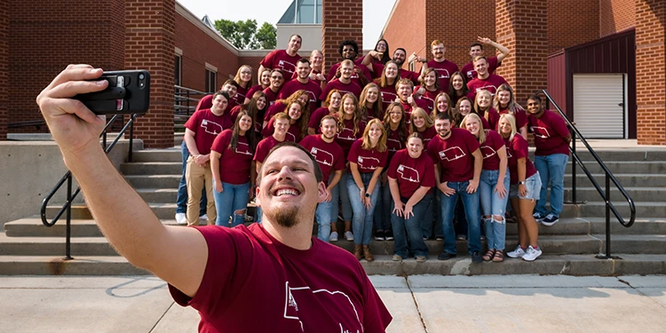 A photo of the Associate director of housing taking a selfie with his staff at CSC