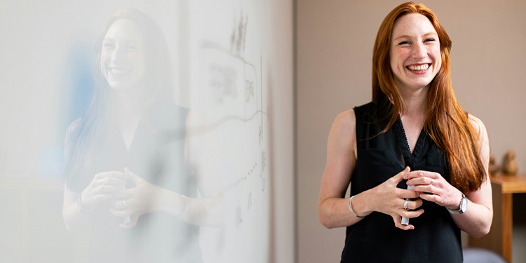 Teacher standing at whiteboard in a classroom 750x375