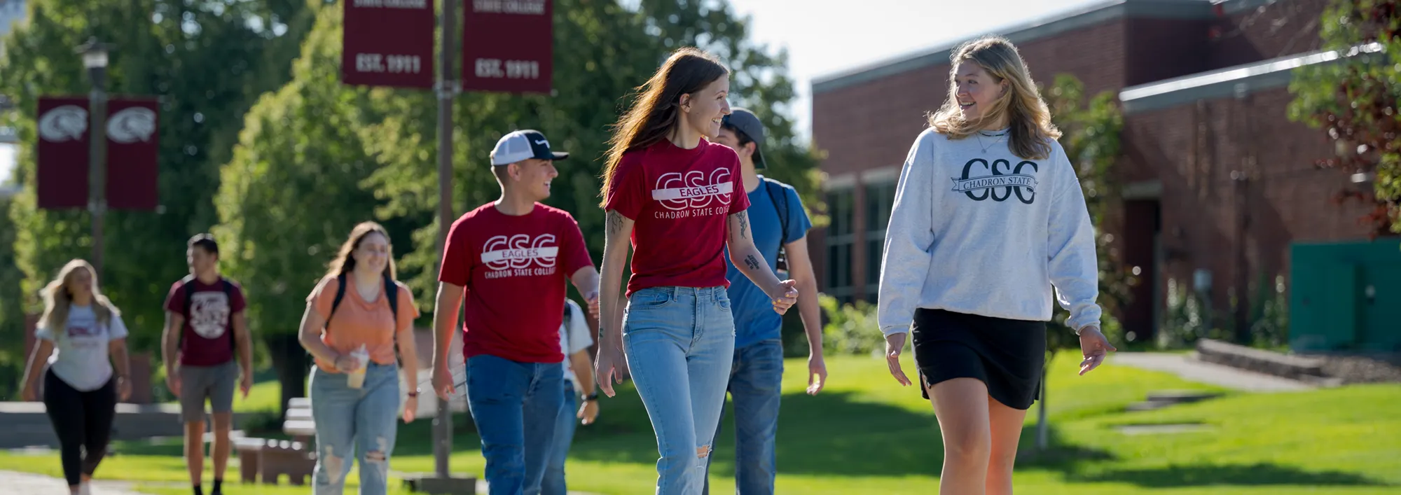 A group of students walking along a sidewalk on the Chadron State College campus
