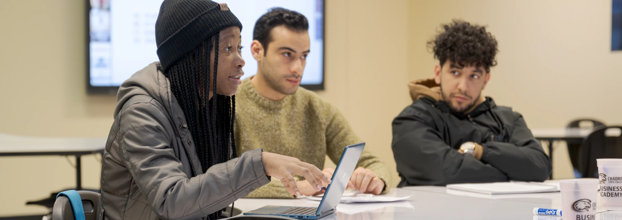 Three students discussing a topic during a graduate business course