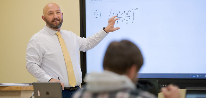 A teacher reviews an equation during a math class