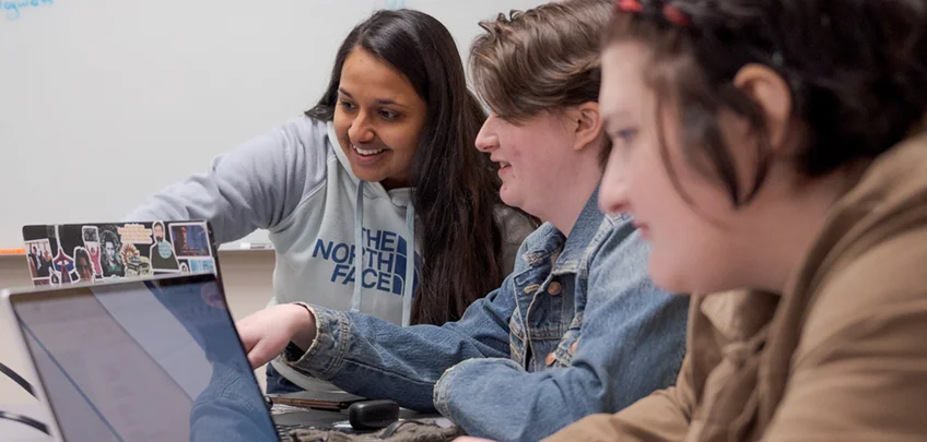 Three students working on laptops