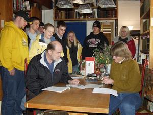With students present, Ken Korte, interim director of the Mari Sandoz High Plains Heritage Center, and Deb Carpenter, CSC writing instructor, sign the contracts to publish a book, 