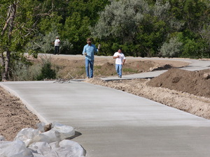 Workers clean up after pouring concrete along this portion of the trail last week.