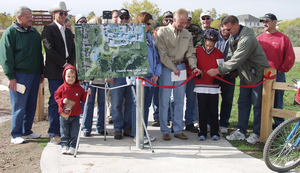 Group of people at a ribbon cutting for trail opening