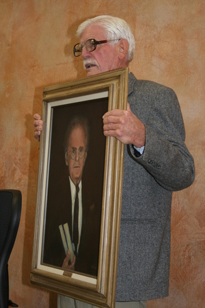 Don Holst holds a painting he did of John Neihardt, long-time Nebraska poet laureate. While working on a master's degree the University of Missouri, Holst worked on Neihardt's horse farm just north of Columbia.
