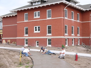 Construction workers form a new sidewalk near Sparks Hall.