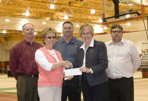 Chadron State College Staff exchange a check