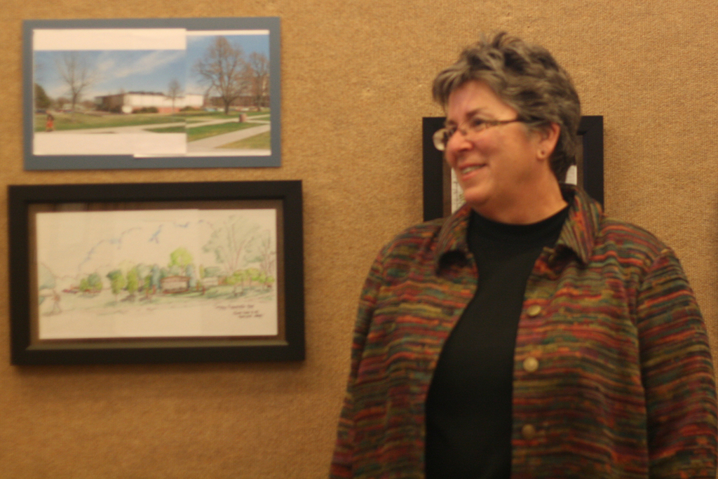 Lucinda Mays, Chadron State College horticulturist, stands near one of her pieces of artwork during the opening reception of her exhibit.