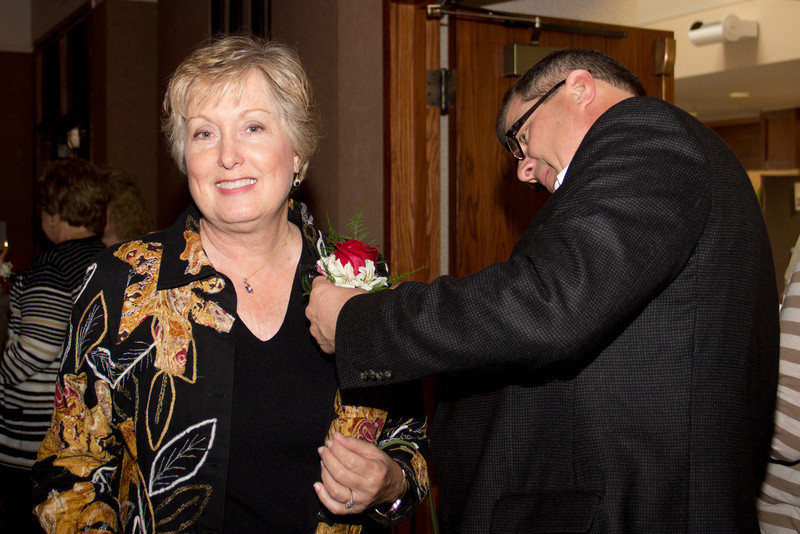 Randy Rhine pins a corsage on Janie Park during a surprise party in her honor May 4. (Photo by Justin Haag)