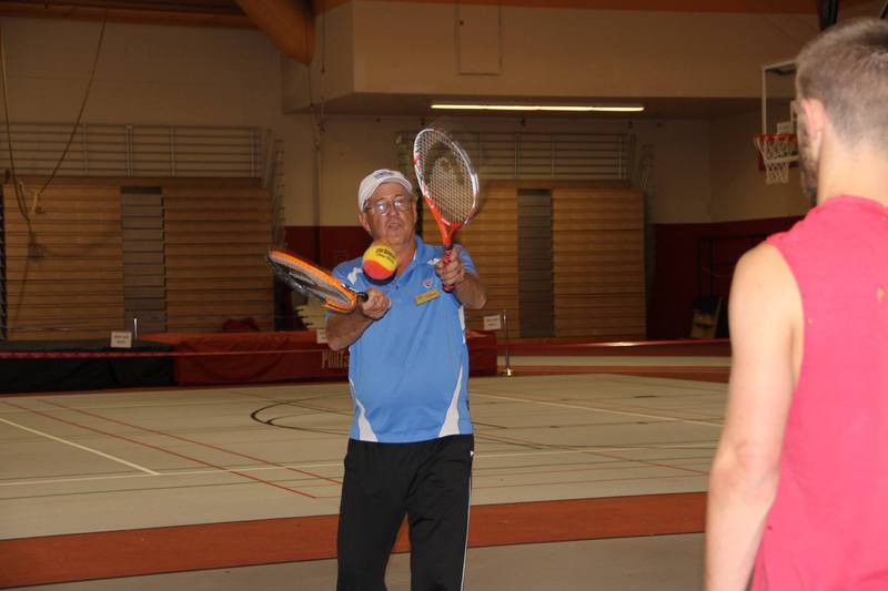Dave Boon, a national United States Tennis Association trainer, demonstrates the lobster trap technique used to teach children 10 and under the basics of tennis in an Oct. 1 workshop. (Tena L. Cook/Chadron State College)