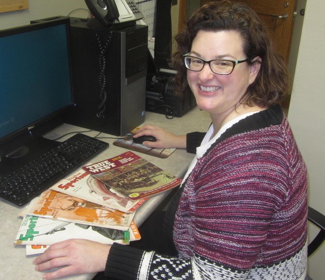 Sarah Polak, director of the Mari Sandoz High Plains Heritage Center at Chadron State College, is picture with some of the original issues of