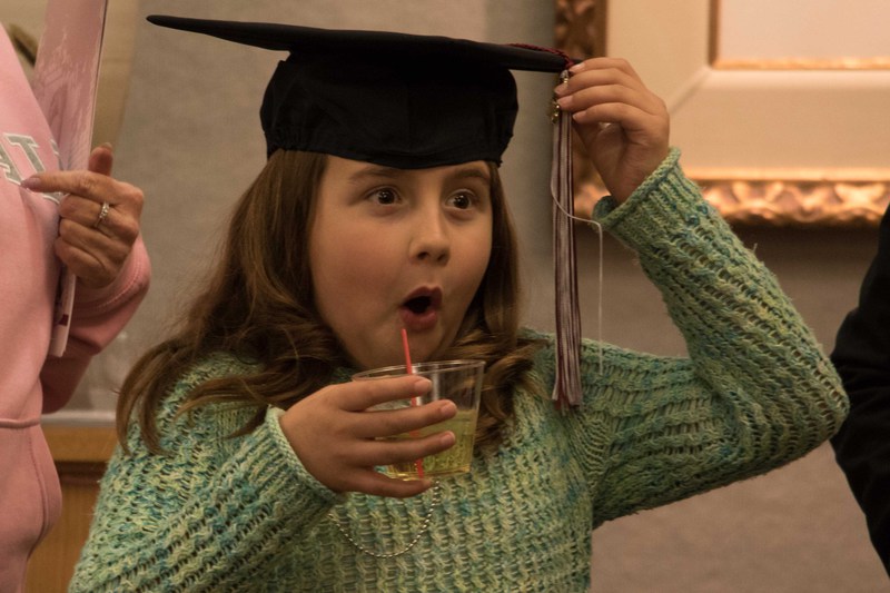 Anna Frederick, daughter of master's graduate Jason Frederick, wears his mortar board at the reception following graduate commencement in the Chadron State College Memorial Hall Lobby Dec. 16, 2016
