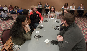 Students participating in the Oxfam Hunger Banquet Monday, Nov. 14, 2016, discuss hunger and food issues, as part of the middle-income contingent.