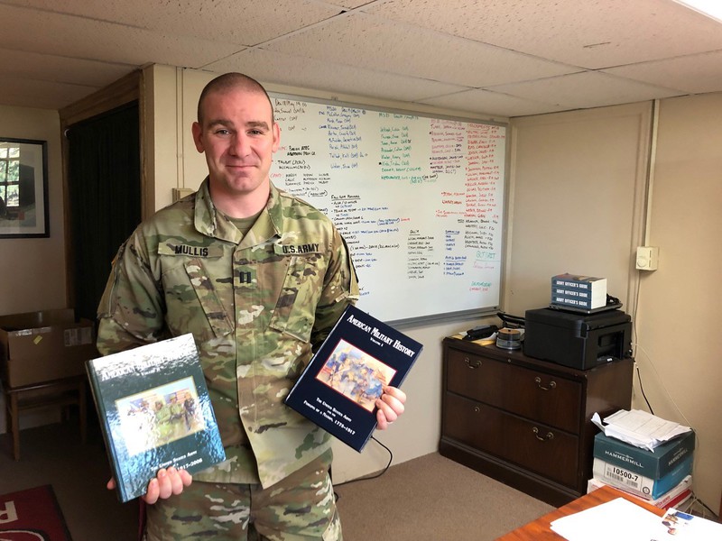 Nebraska Army National Guard Capt. Scot Mullis, associate professor of military science at Chadron State College, shows some of the text books used in the Military Science and Leadership courses he teaches.