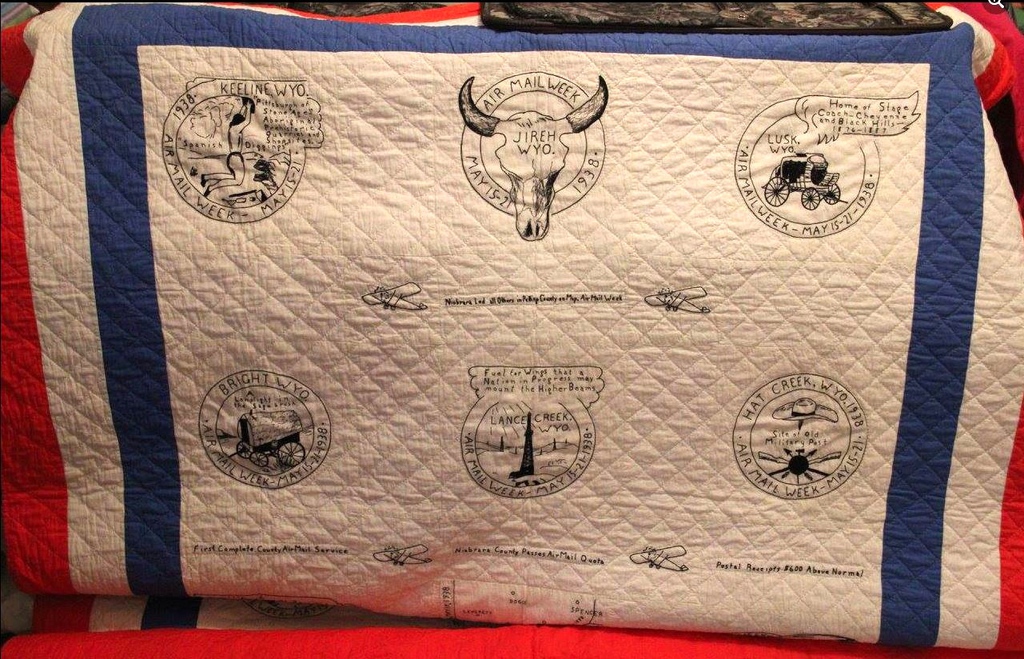 An older quilt is draped over something that displays graphics from different periods of time and struggles in 1938.