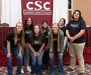 Seven CSC Social Work students pose in front of CSC backdrop for virtual conference.