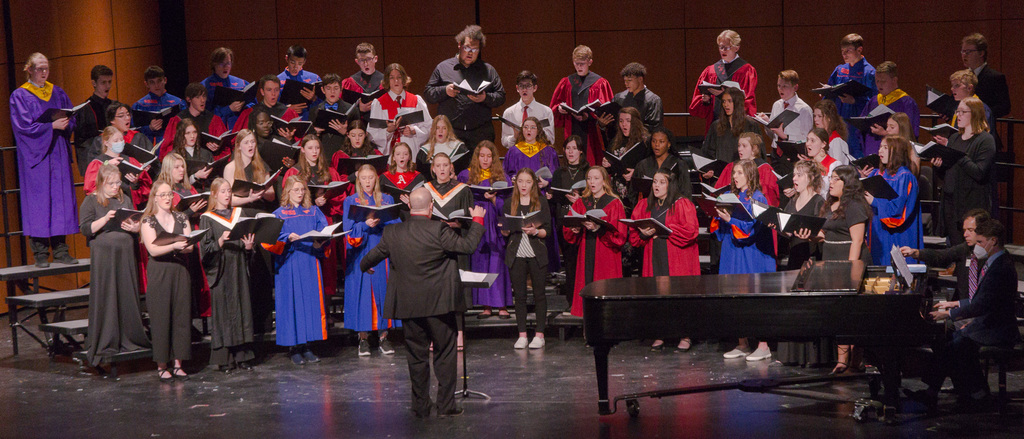 A large choir sings on a stage