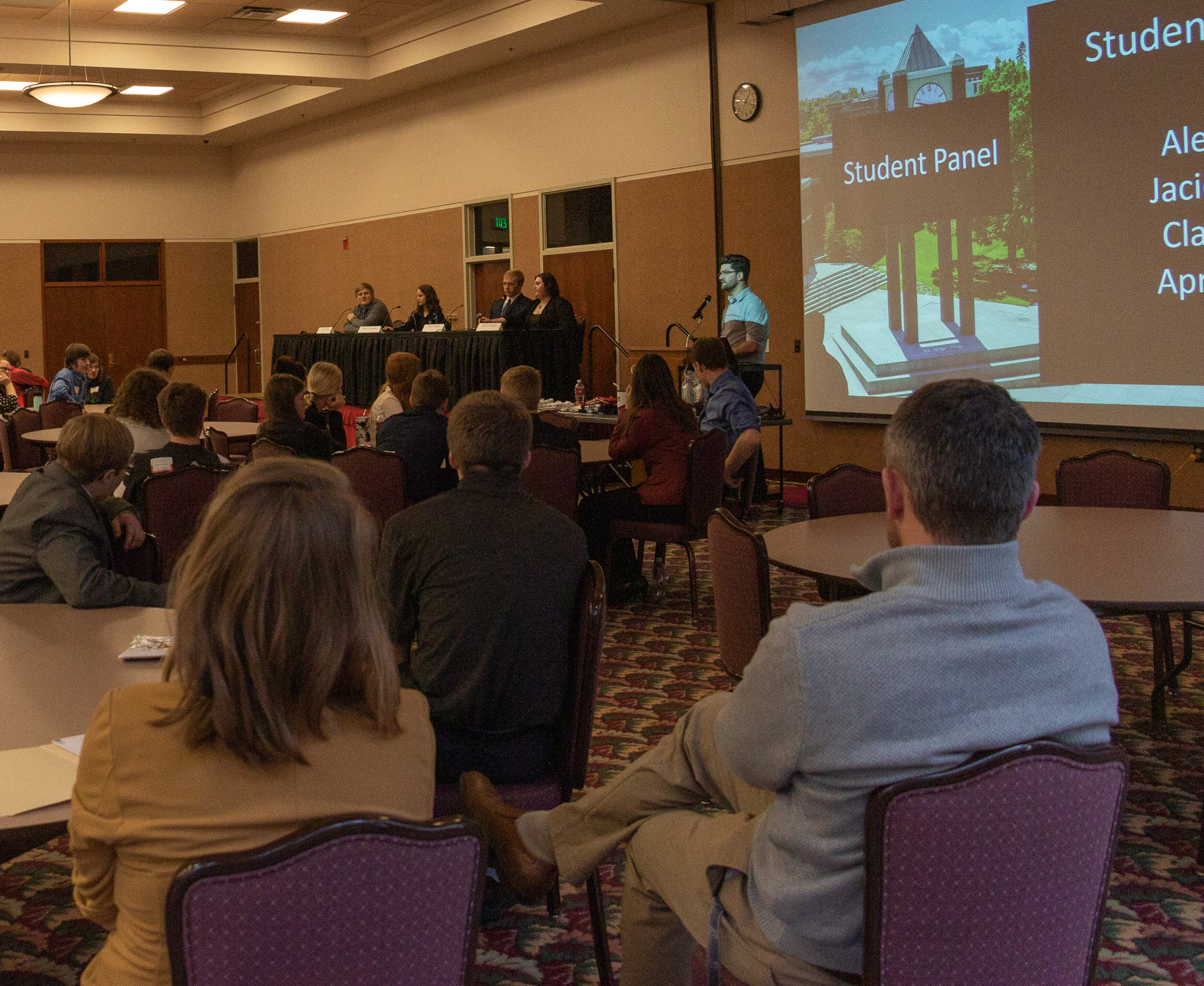 People in a conference room with a panel discussion