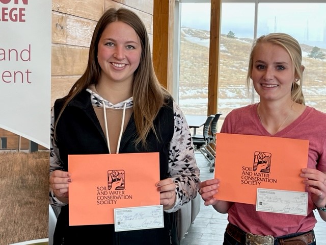 Two students posing with certificates