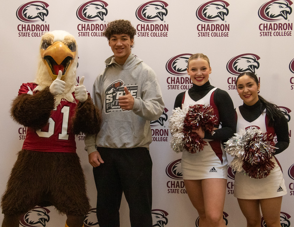 Three students posing with eagle mascot