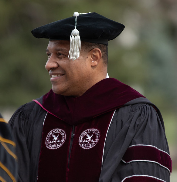 Adult male in academic regalia outdoors
