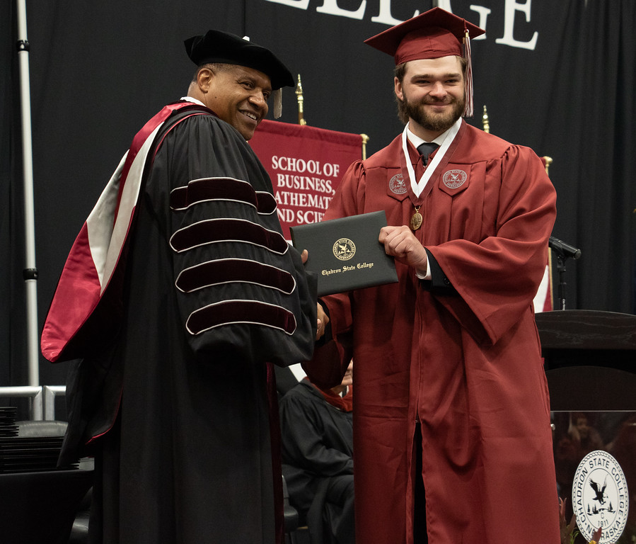 Two adults males posing on stage at graduation