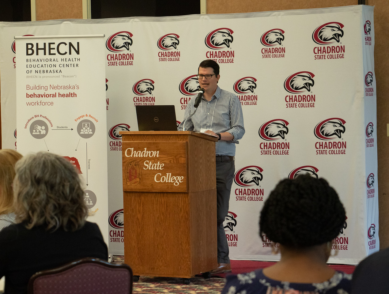 Man at a podium speaking to an audience