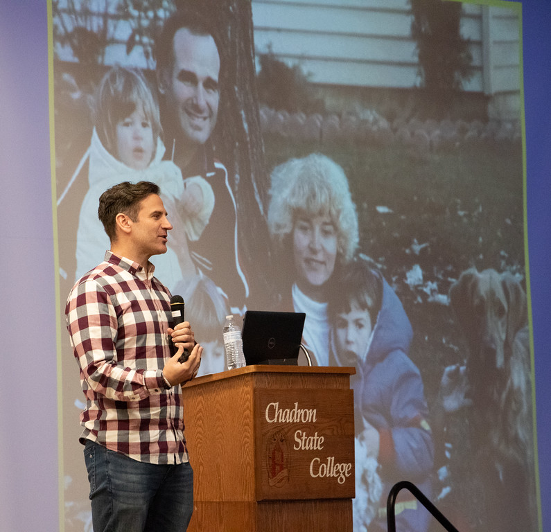Male speaker in front of slide presentation
