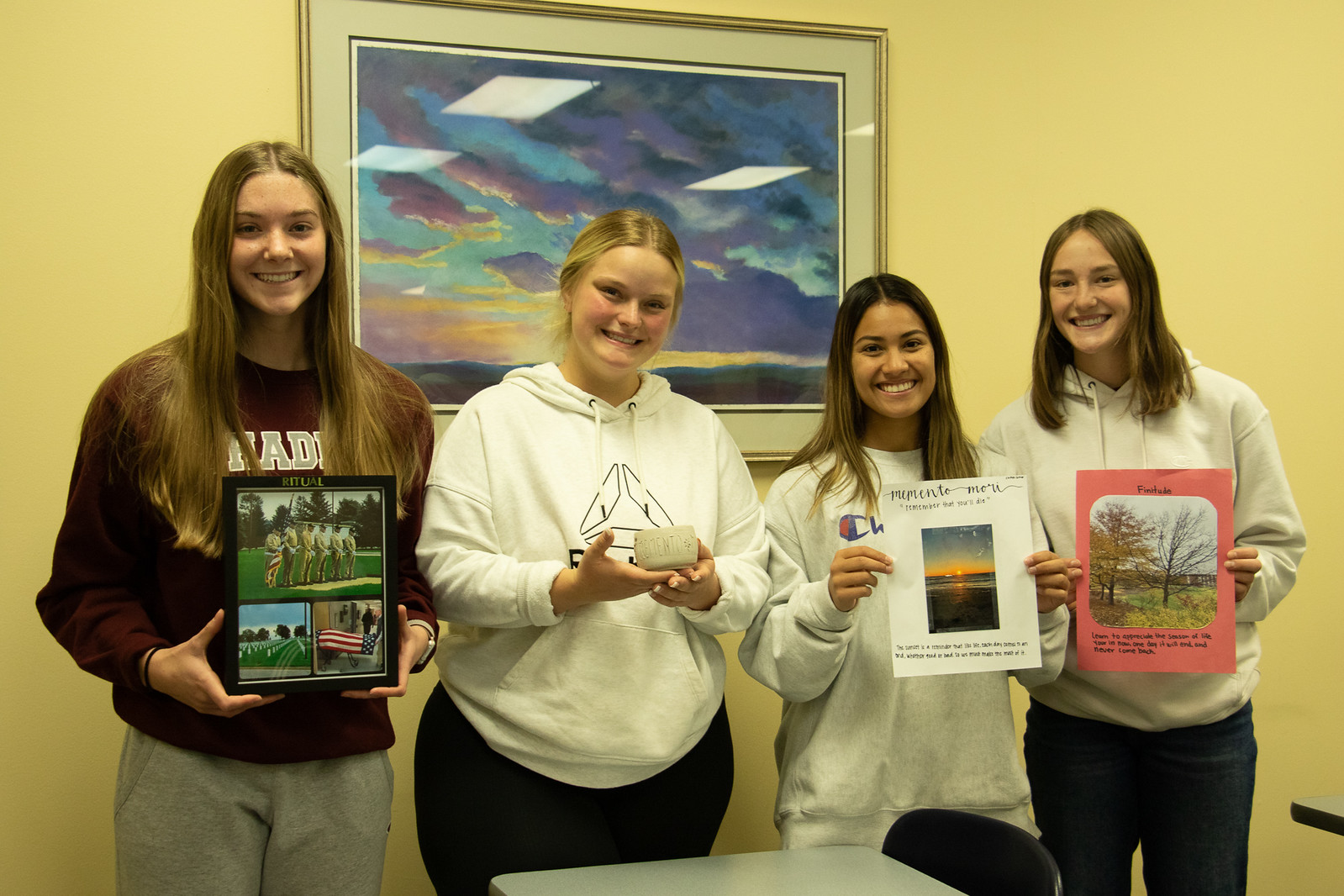 Four women posing with art