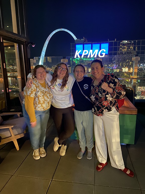 Group of adults posing by the St Louis Arch