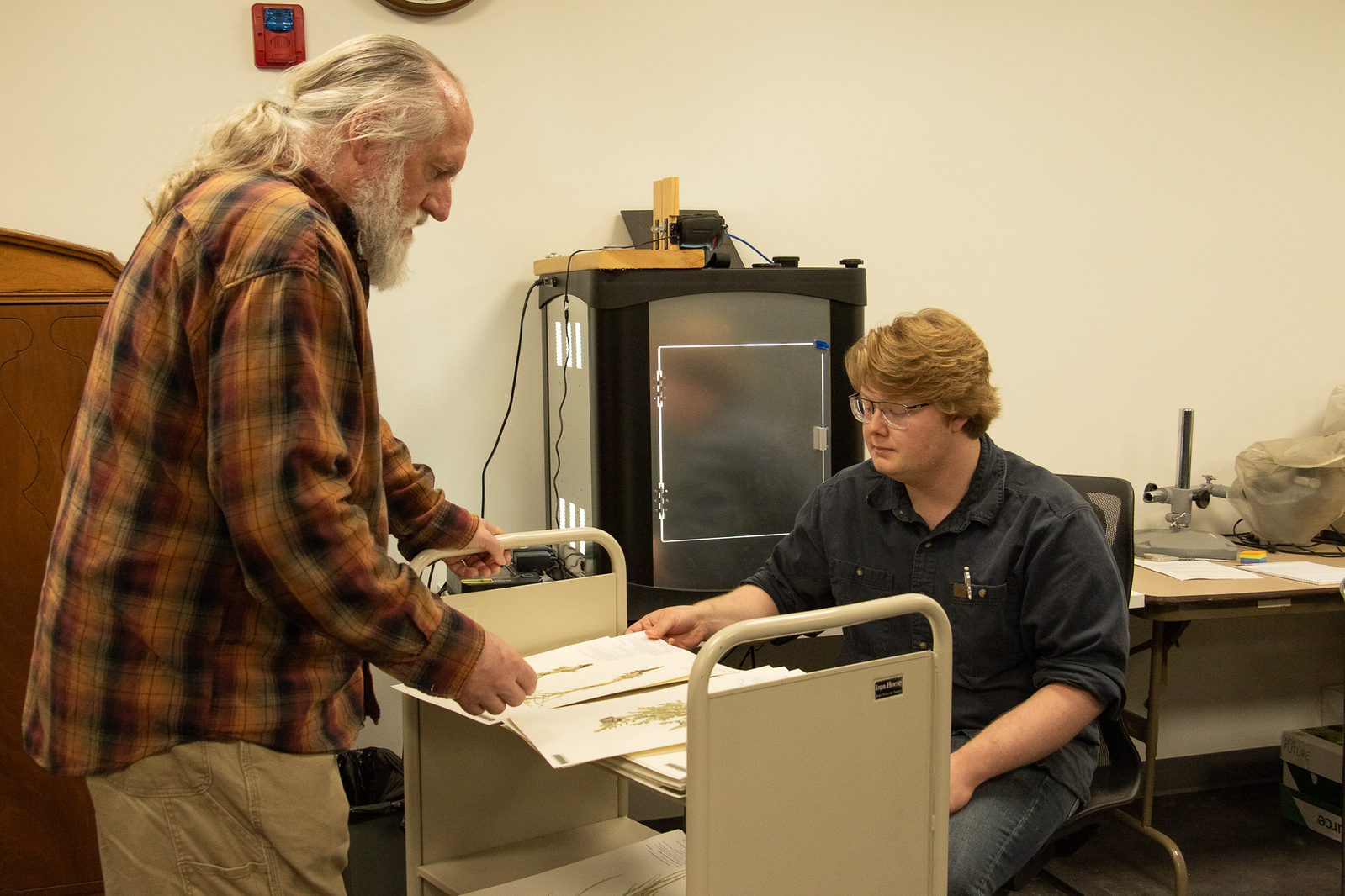 Two male scientists looking at plant specimens