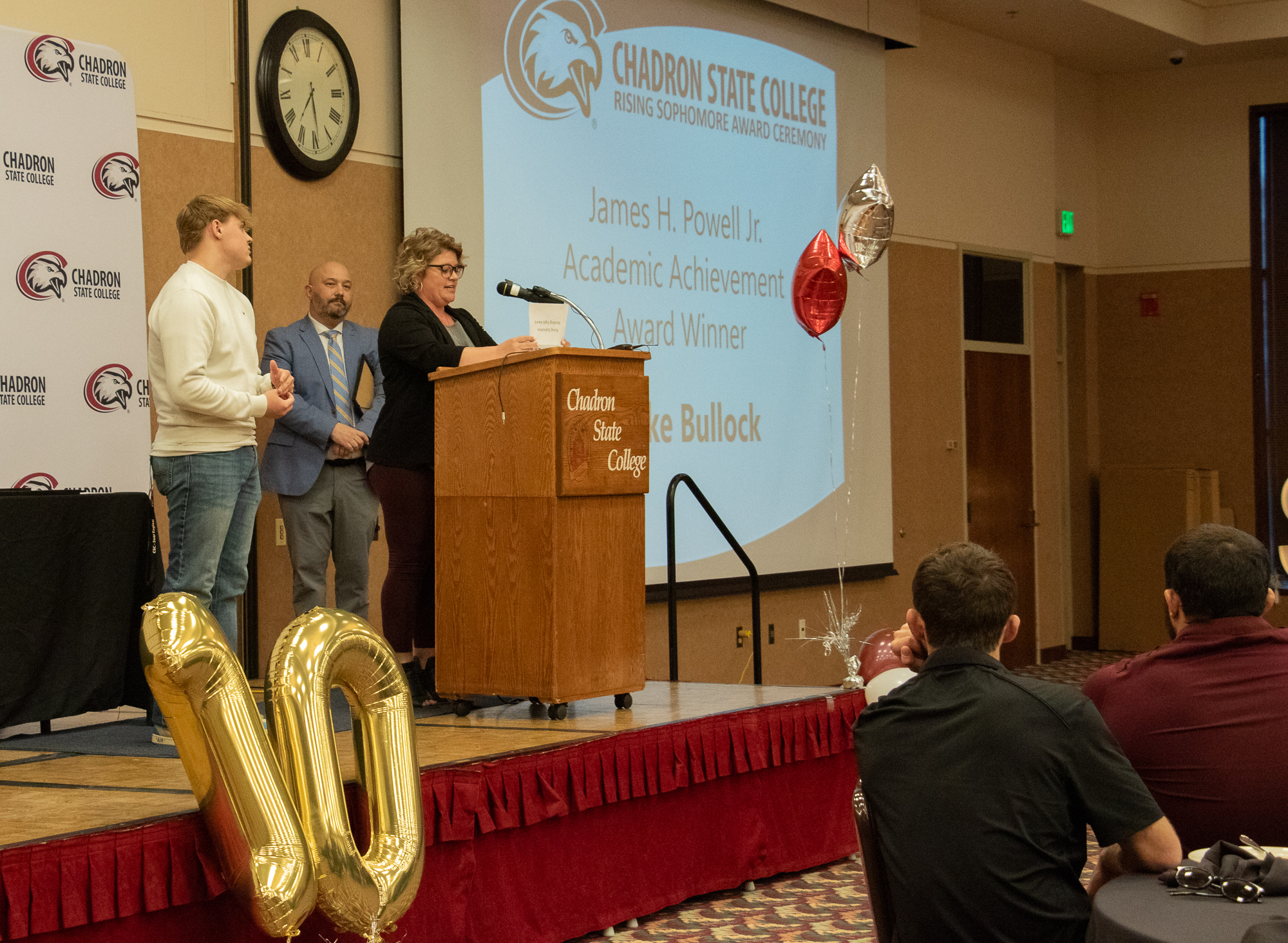 Adults on stage during an awards ceremony