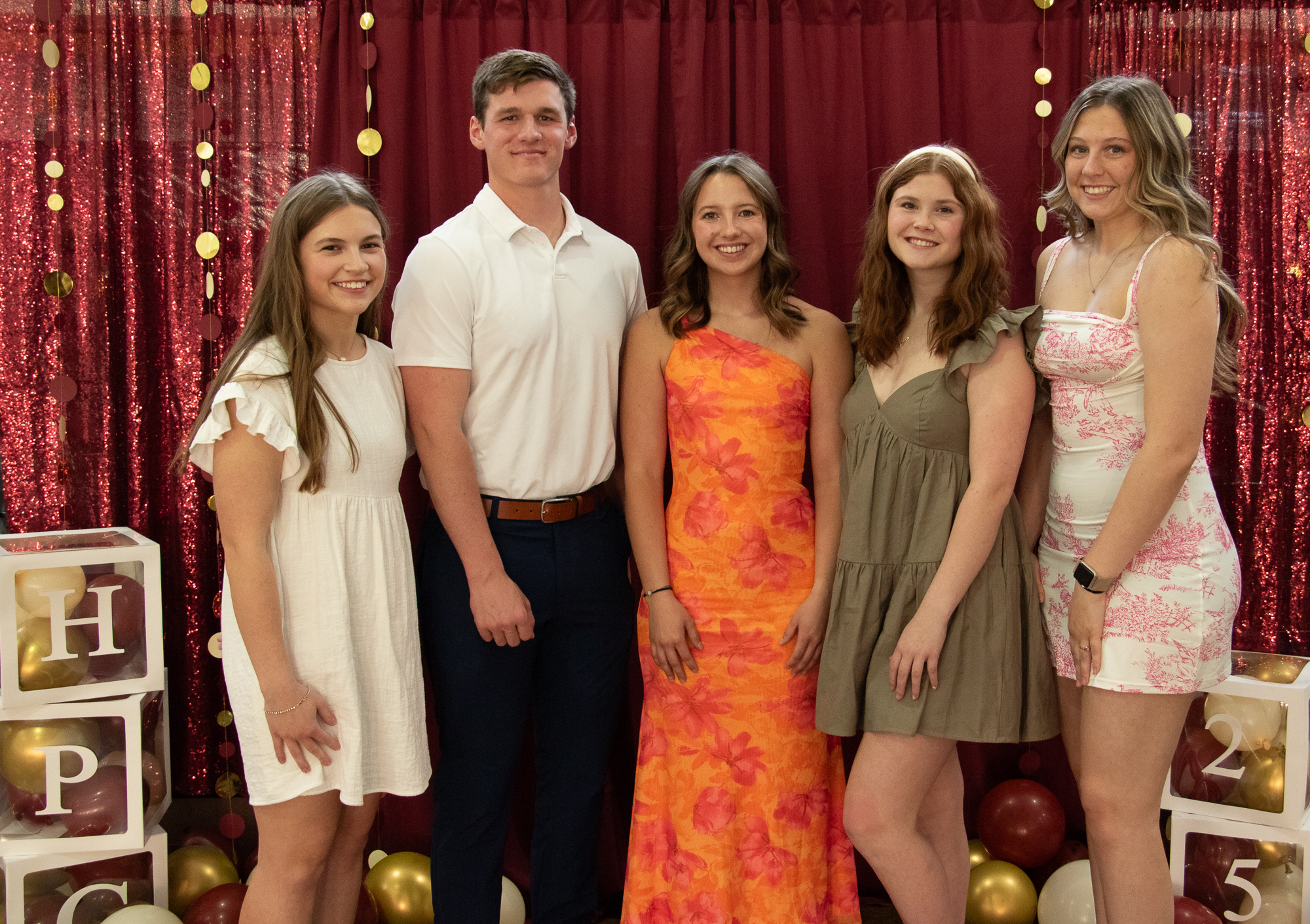 Students posing in front of a backdrop