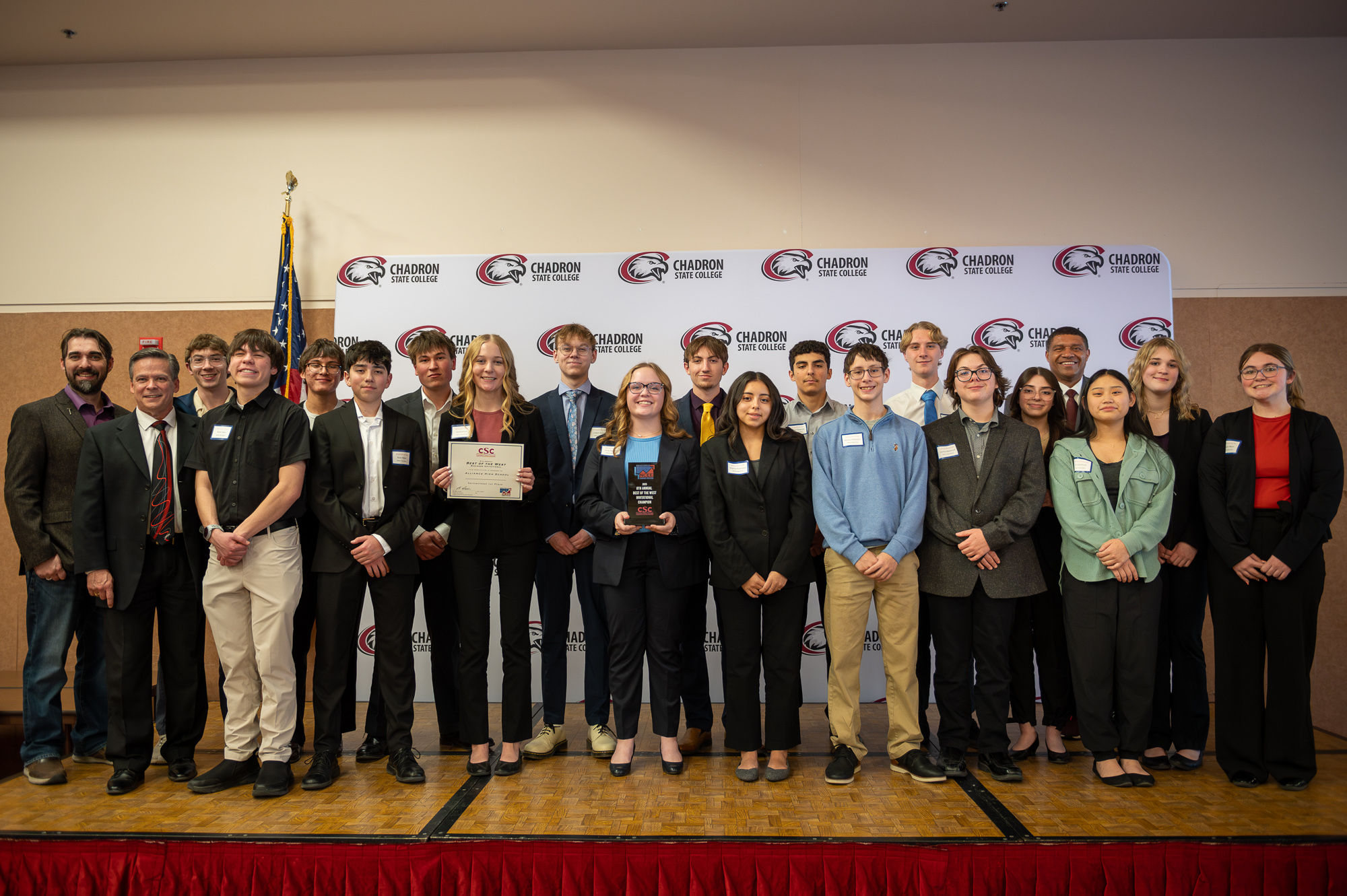 Image of Alliance High School students standing on a stage with a CSC backdrop holding the first place award.