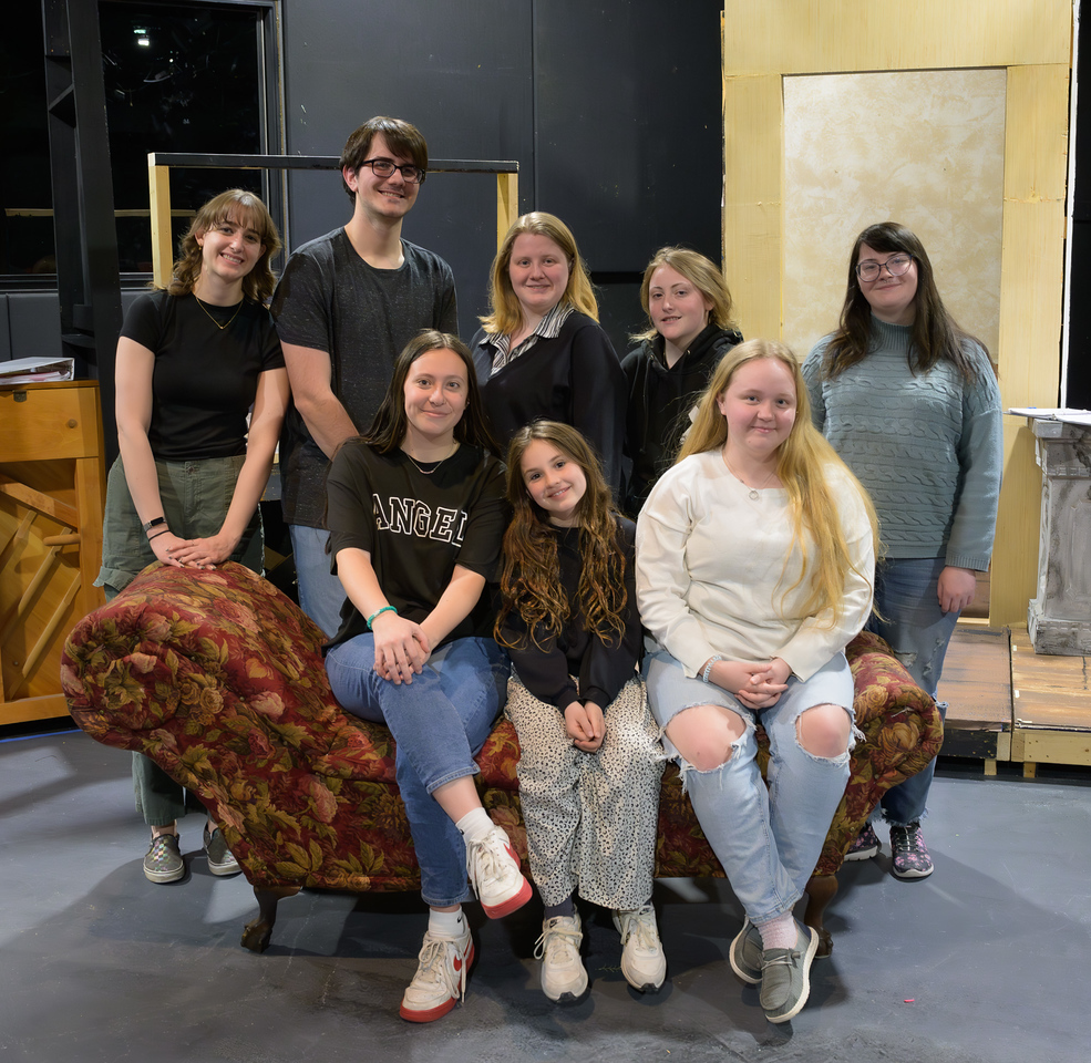 Cast of play posing on stage