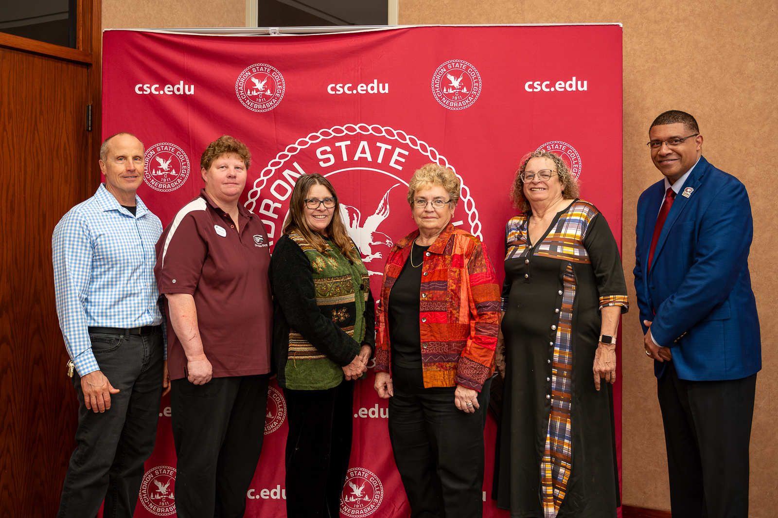 A group of adults posing with awards