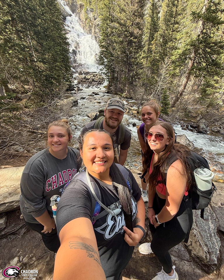 Group posing by a waterfall