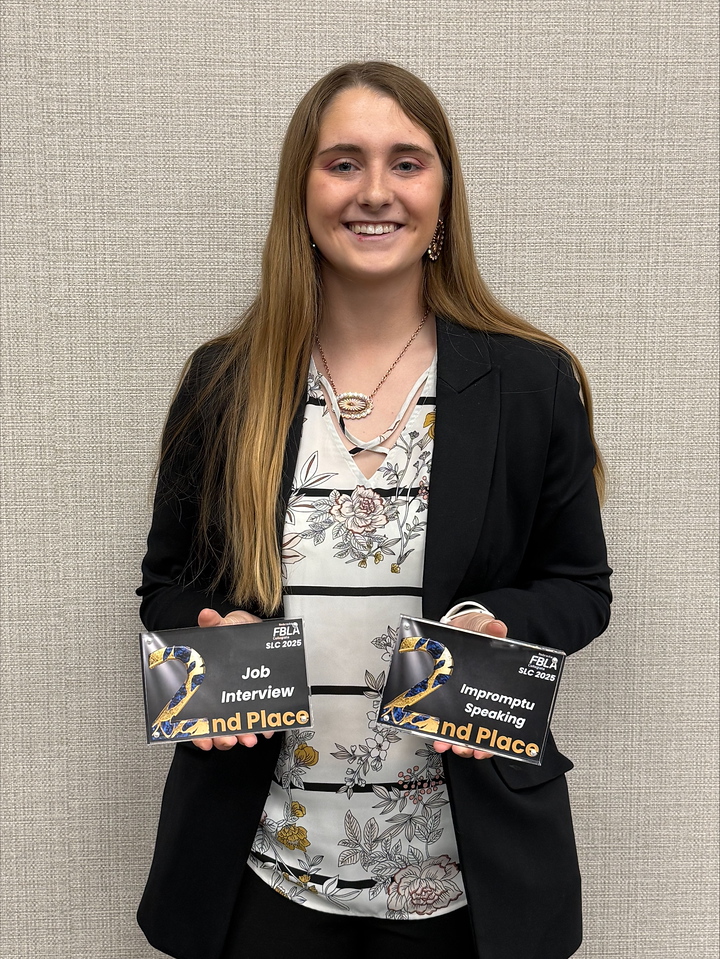 Female student holding awards