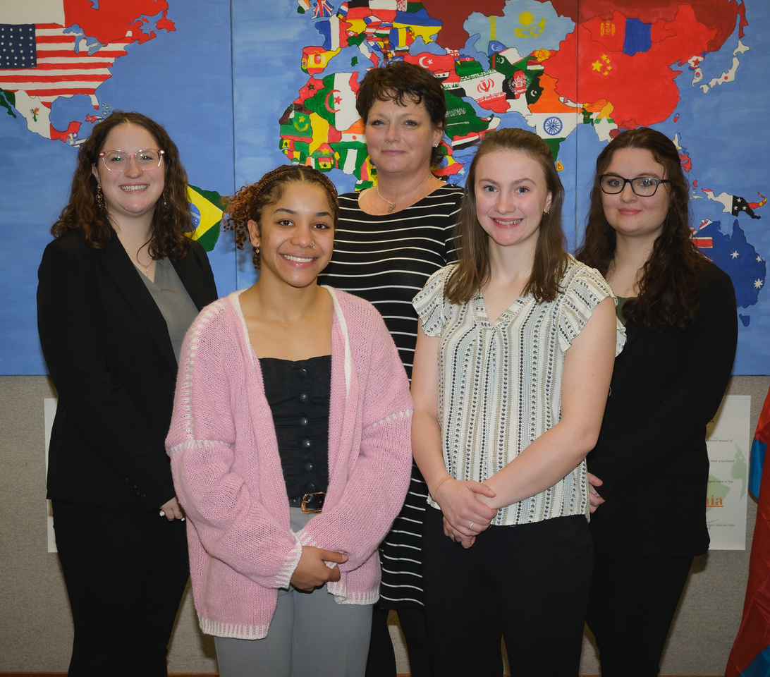 Five students posing inside