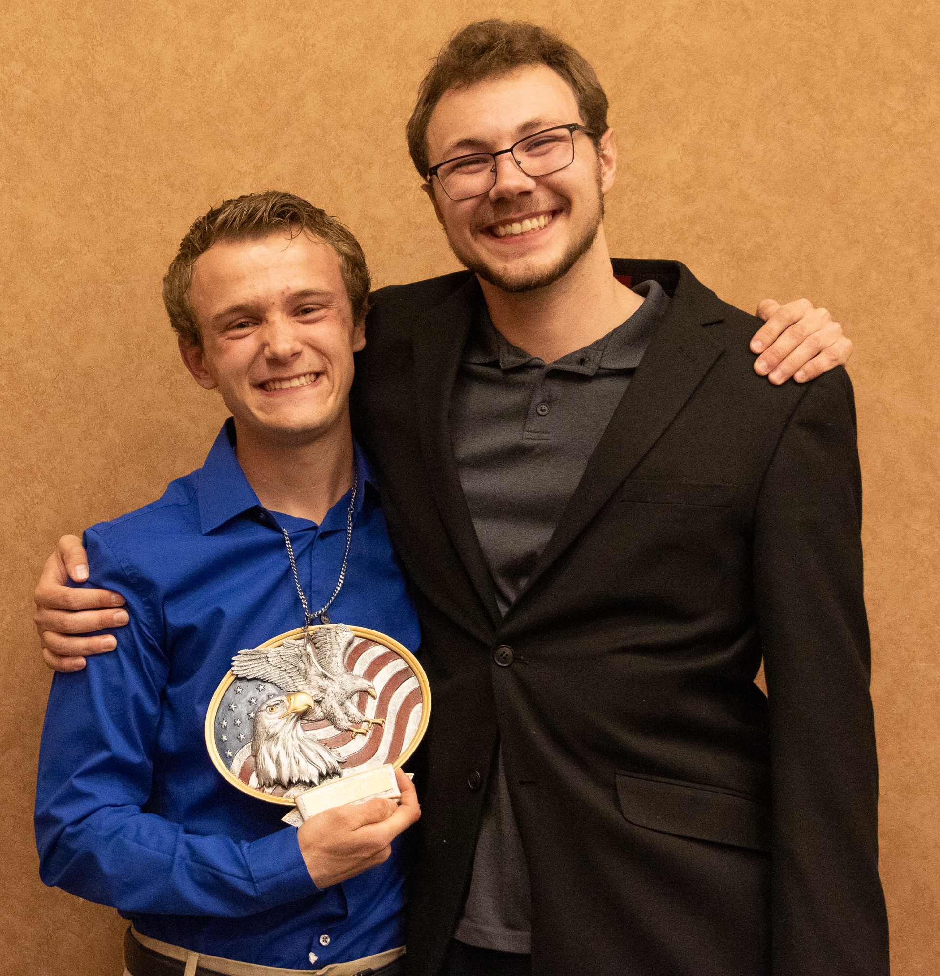 Two students holding an award