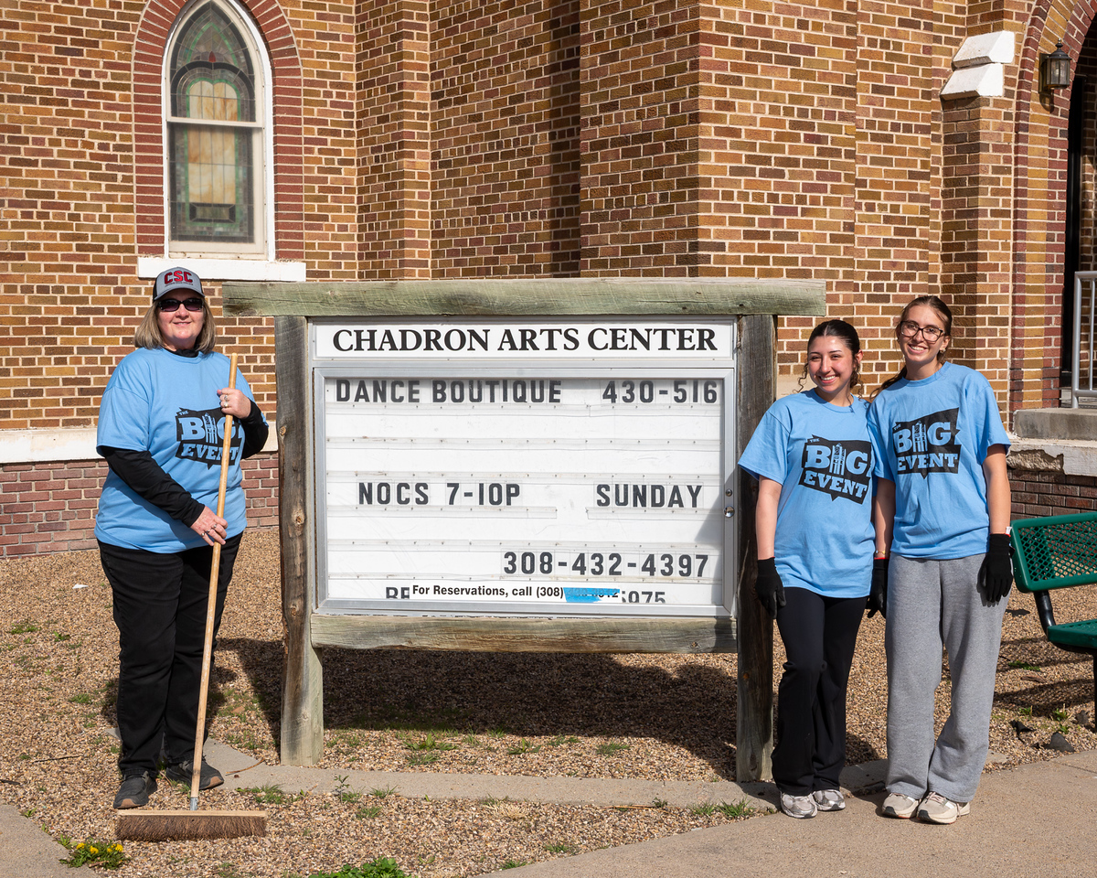 Three people posing by an arts center