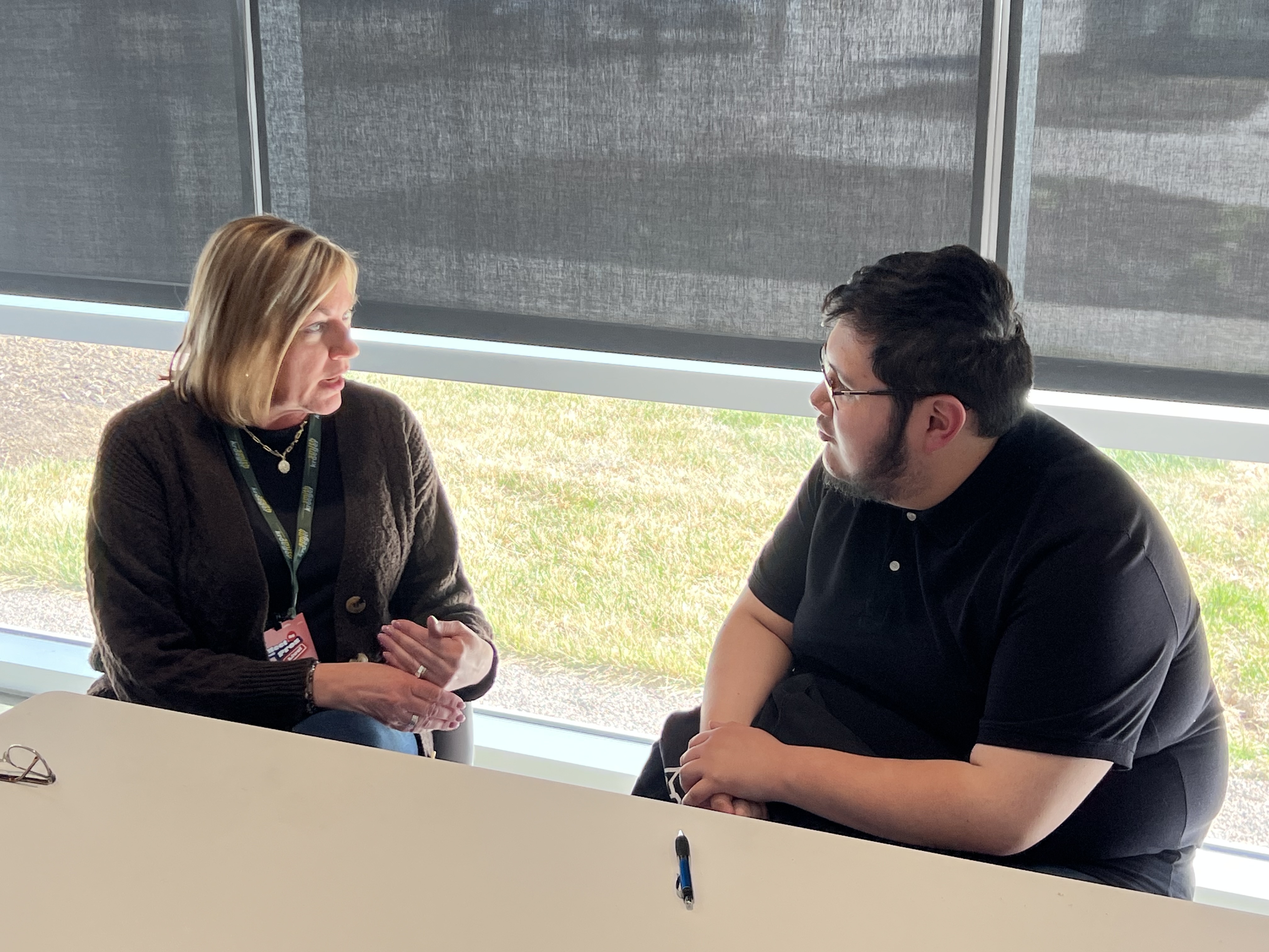 A student talking with a graphic design professional