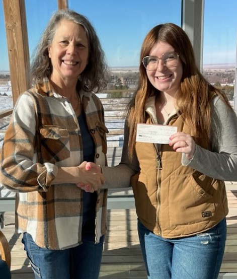 Two women posing with a check